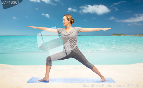 Image of woman making yoga warrior pose on mat
