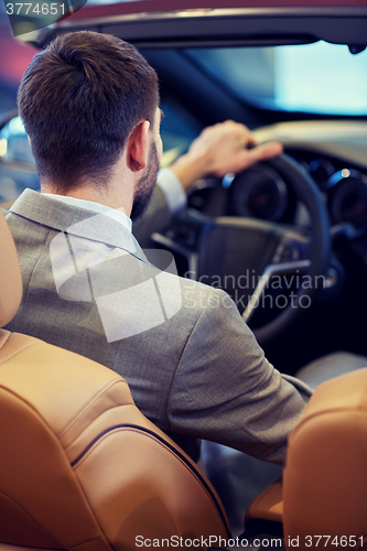 Image of close up of man in cabriolet car at auto show