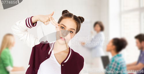 Image of bored student girl making finger gun gesture