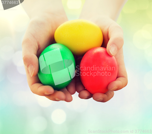 Image of close up of kid hands holding colored eggs