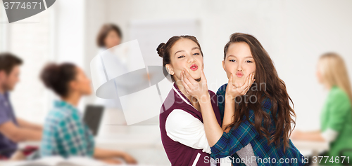 Image of happy teenage student girls having fun at school