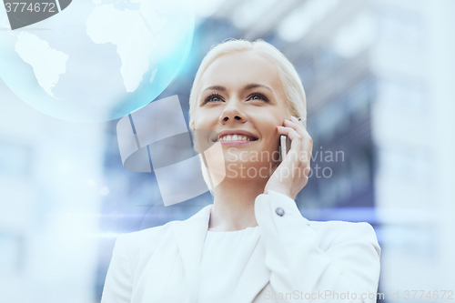 Image of smiling businesswoman with smartphone outdoors