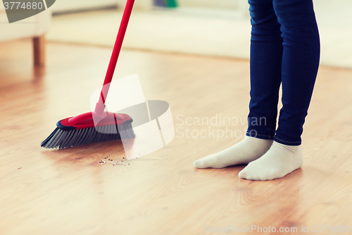 Image of close up of woman legs with broom sweeping floor