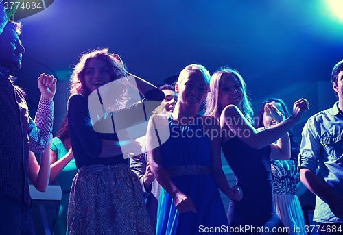 Image of group of happy friends dancing in night club