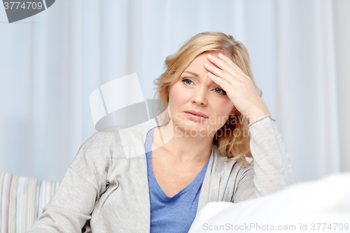 Image of woman suffering from headache at home