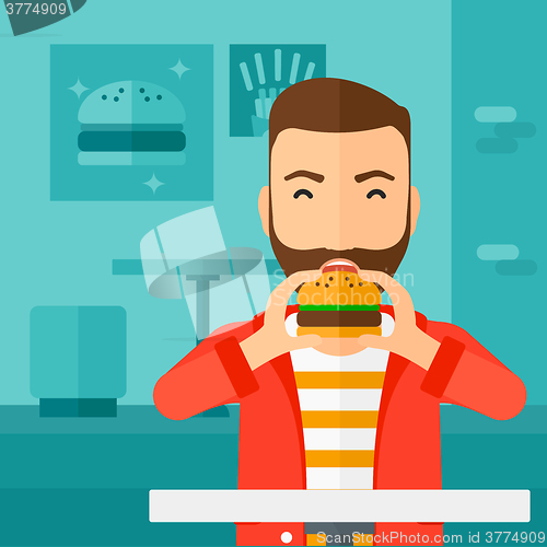 Image of Man eating hamburger. 