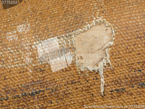 Image of Detail (damage) of an old canvas suitcase, close-up