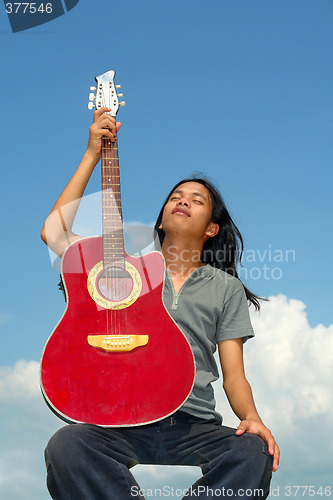 Image of Asian guitar player taking break