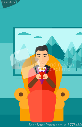 Image of Man sitting in chair with cup of tea.