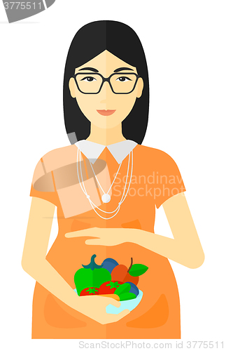 Image of Pregnant woman with vegetables.