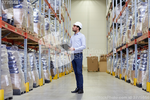 Image of happy businessman with clipboard at warehouse