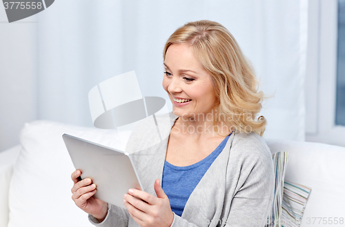 Image of happy middle aged woman with tablet pc at home