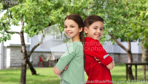 Image of happy boy and girl standing together over backyard