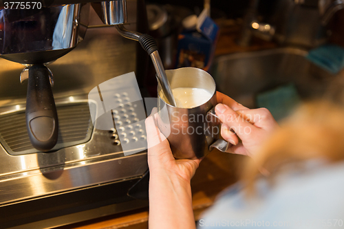 Image of close up of woman making coffee by machine at cafe