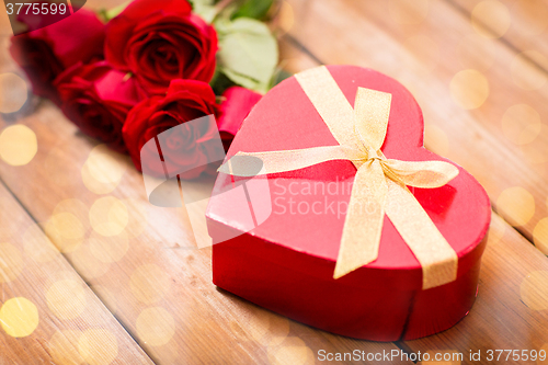 Image of close up of heart shaped gift box and red roses