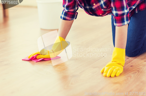 Image of close up of woman with rag cleaning floor at home