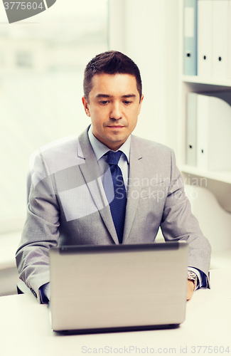 Image of businessman working with laptop in office