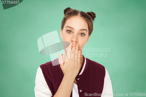 Image of confused teenage student girl covering her mouth