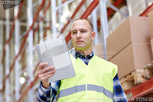 Image of manual worker with tablet pc at warehouse