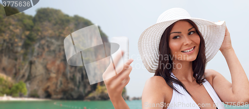 Image of young woman taking selfie with smartphone