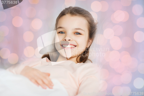 Image of happy smiling girl lying awake in bed at home