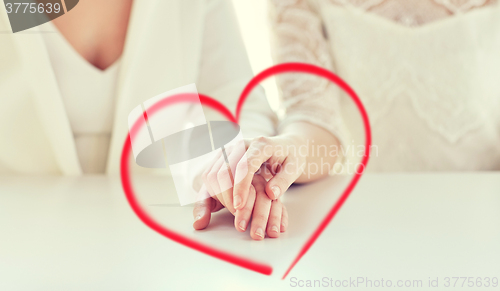 Image of close up of happy married lesbian couple hands