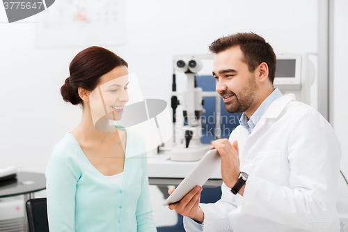 Image of optician with tablet pc and patient at eye clinic