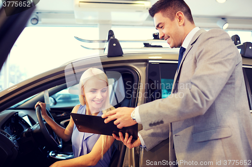 Image of happy woman with car dealer in auto show or salon