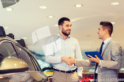 Image of happy man shaking hands in auto show or salon