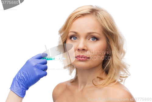 Image of woman face and beautician hand with syringe