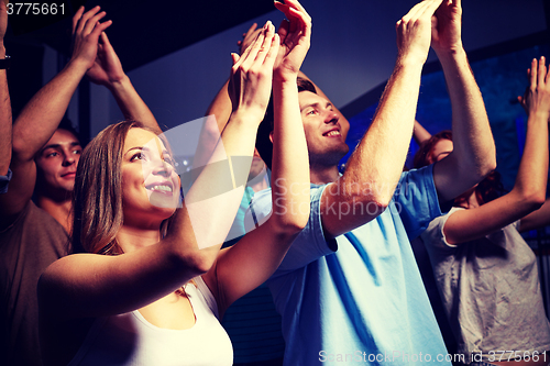 Image of smiling friends at concert in club