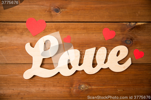 Image of close up of word love with red paper hearts