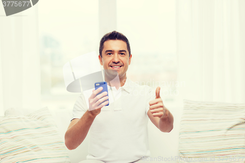 Image of happy man with smartphone at home