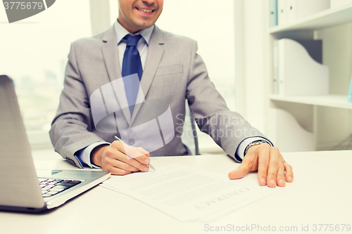 Image of close up of businessman with laptop and papers