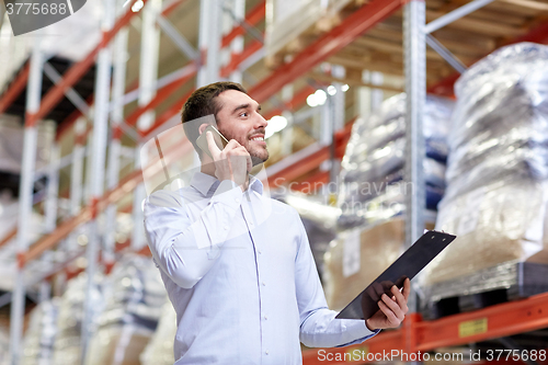 Image of man with clipboard and smartphone at warehouse