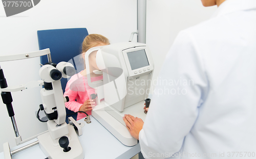 Image of optician with autorefractor and kid at eye clinic