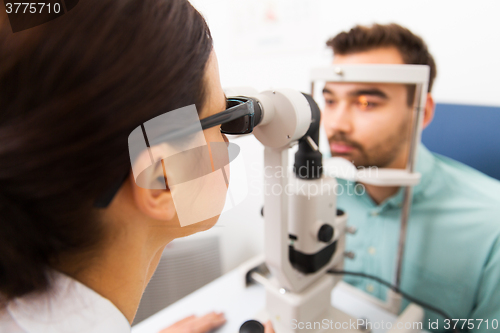 Image of optician with slit lamp and patient at eye clinic