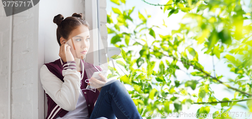 Image of teenage girl with smartphone and earphones