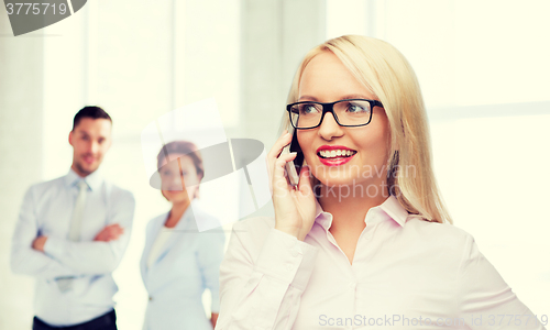 Image of smiling businesswoman calling on smartphone