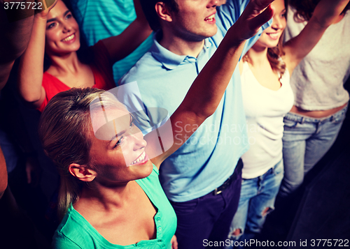 Image of smiling friends at concert in club