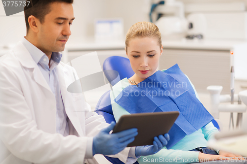 Image of male dentist with tablet pc and woman patient