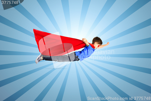 Image of boy in red superhero cape and mask flying on air