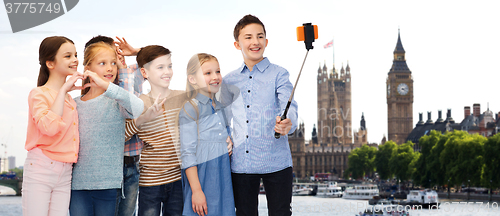 Image of happy children with smartphone and selfie stick
