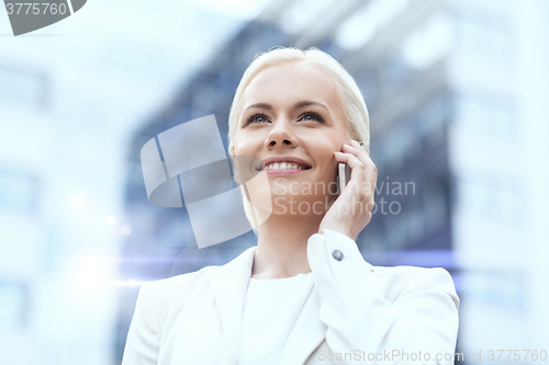 Image of smiling businesswoman with smartphone outdoors