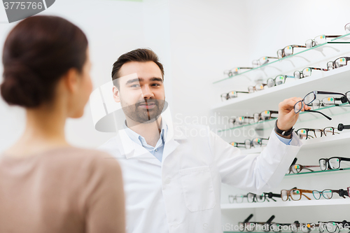 Image of woman and optician showing glasses at optics store