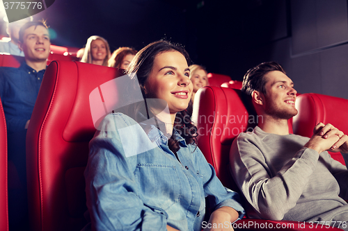 Image of happy friends watching movie in theater