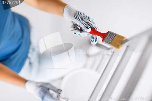 Image of woman with paintbrush and paint pot