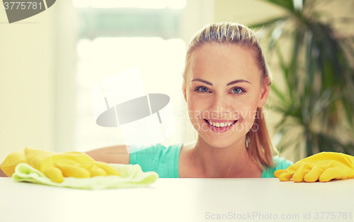 Image of happy woman cleaning table at home kitchen