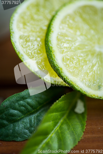 Image of lime slices on wooden table