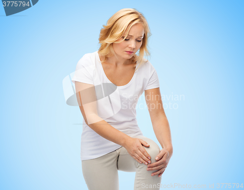 Image of unhappy woman suffering from pain in leg